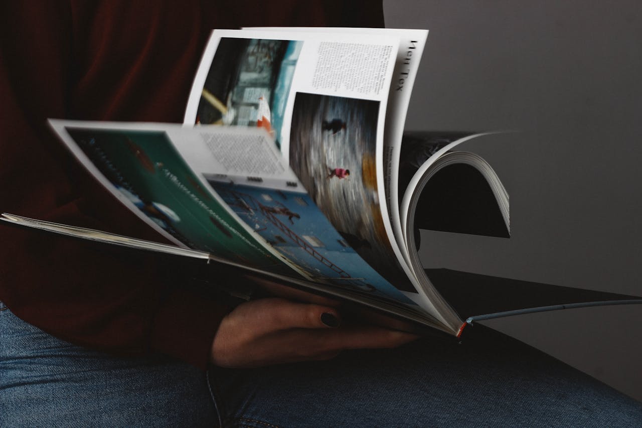A person flips through a photography book, emphasizing the visuals.