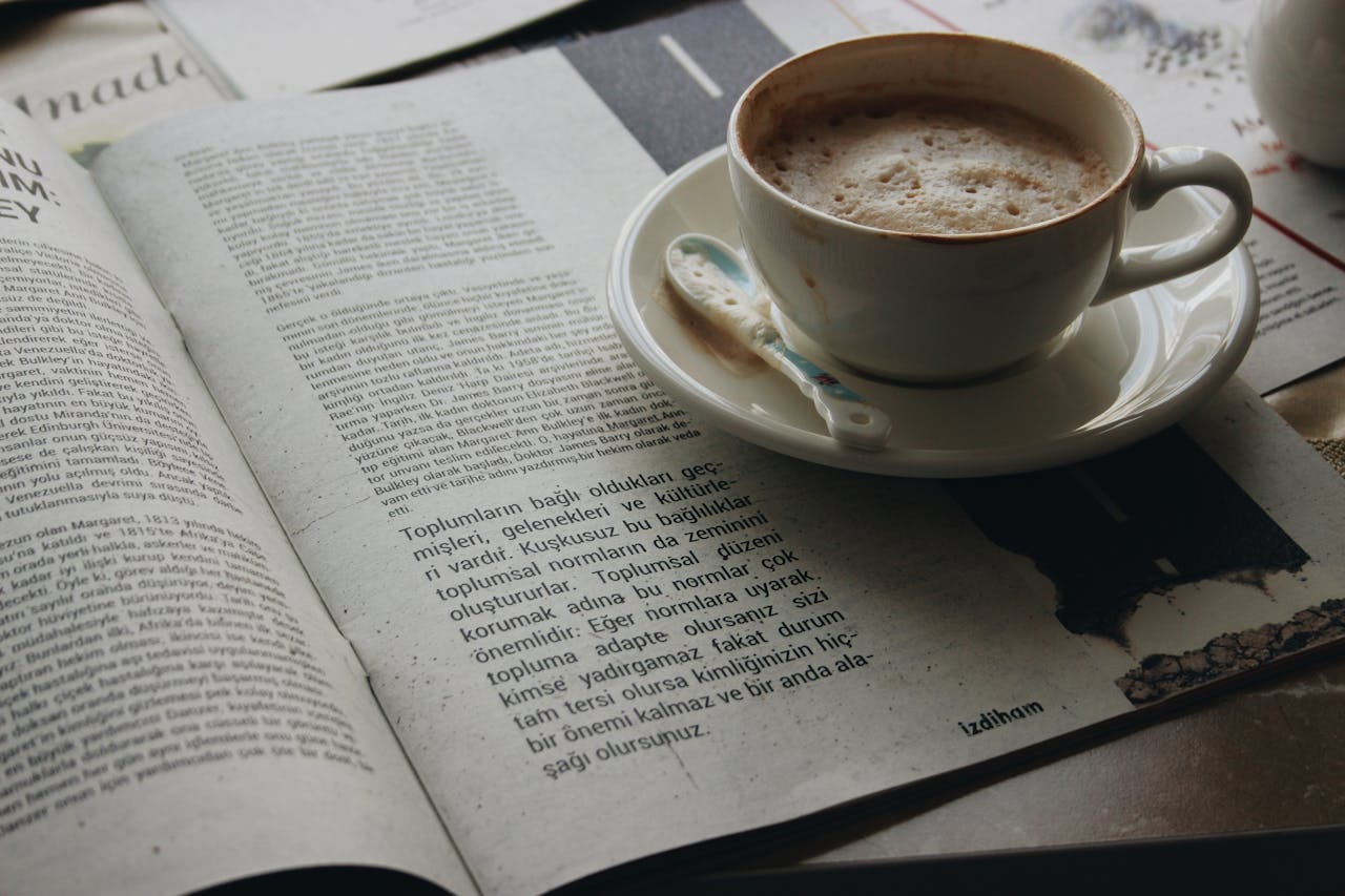 A cozy morning setup with a cup of coffee beside an open newspaper, ideal for relaxation themes.